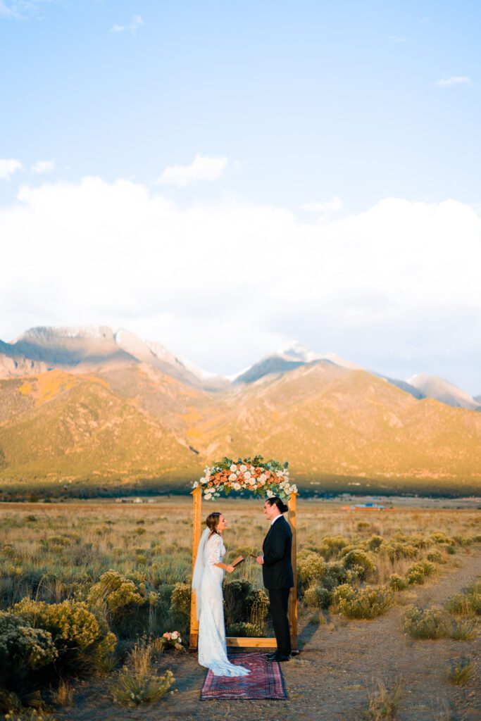 bride and groom reading their vows to eachother with the mountains in the background during their colorado springs elopement