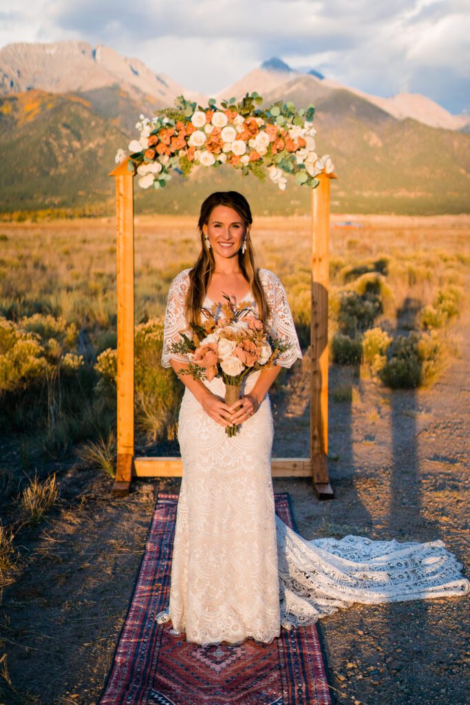 bride standing in front of the arbor during her colorado springs elopement near crestone