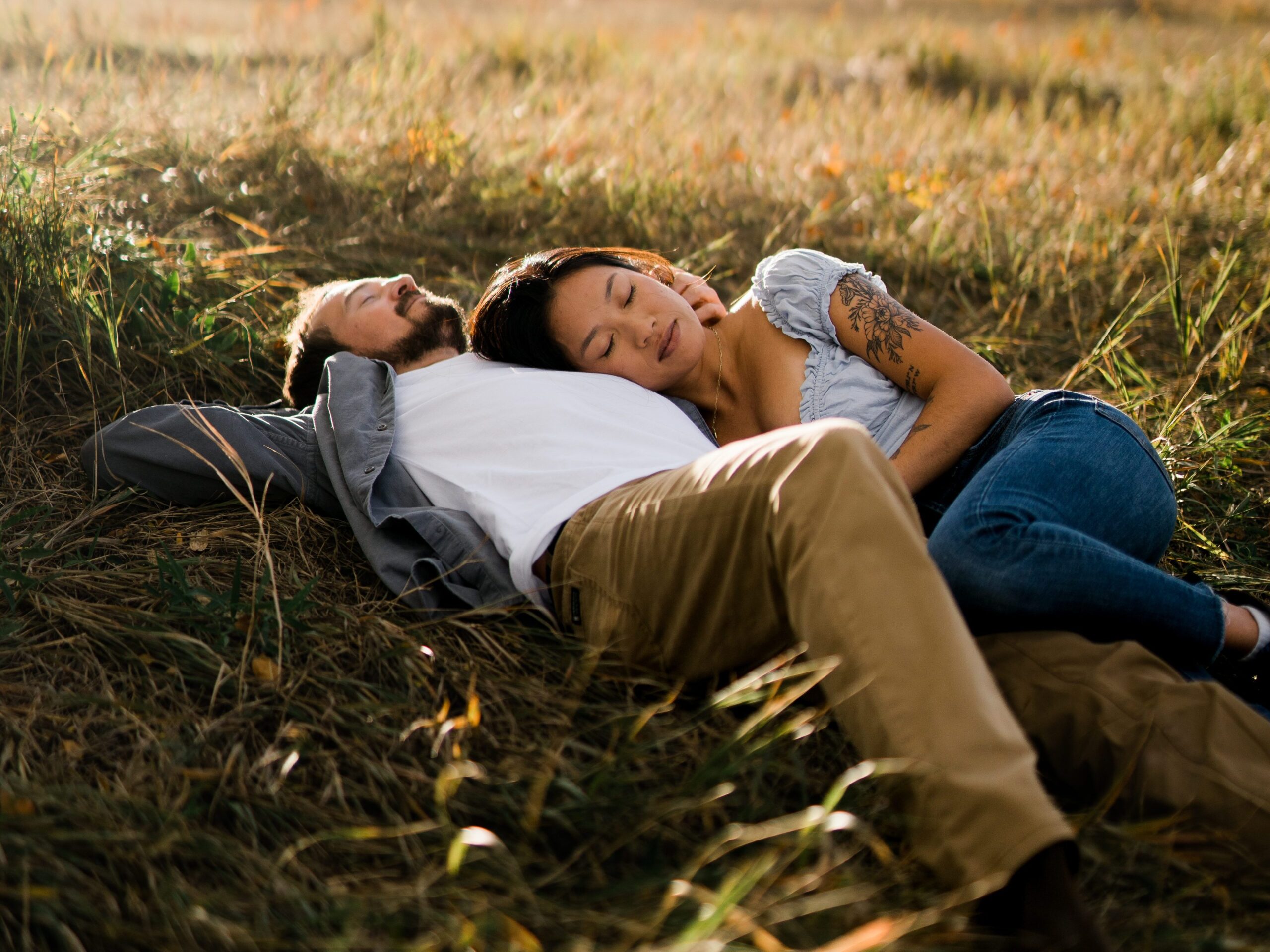 engaged couple laying in a field together in boulder colorado during their Chautauqua Park Engagement Photos