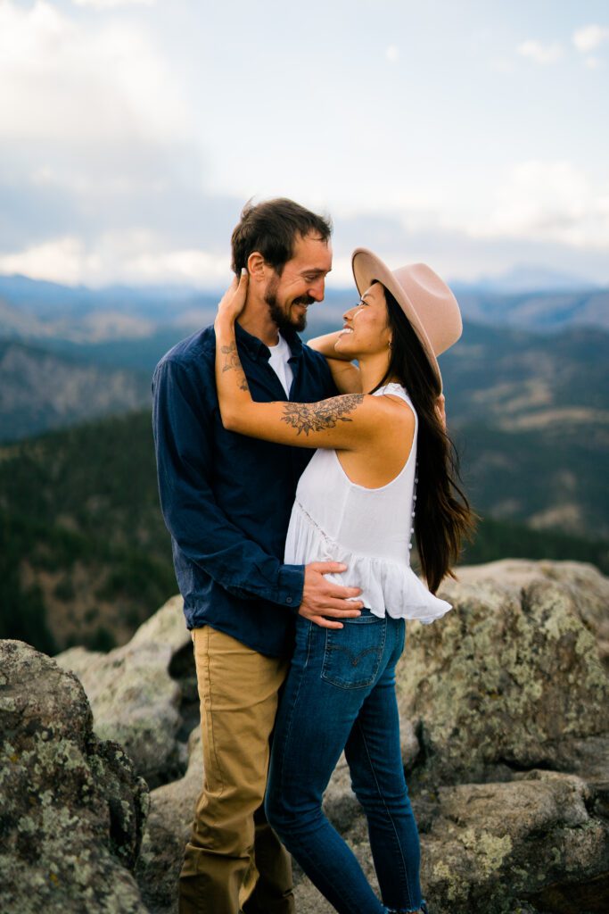 cute engaged couple standing on a mountain outside of boulder colorado at lost gulch overlook during their Chautauqua Park Engagement Photos