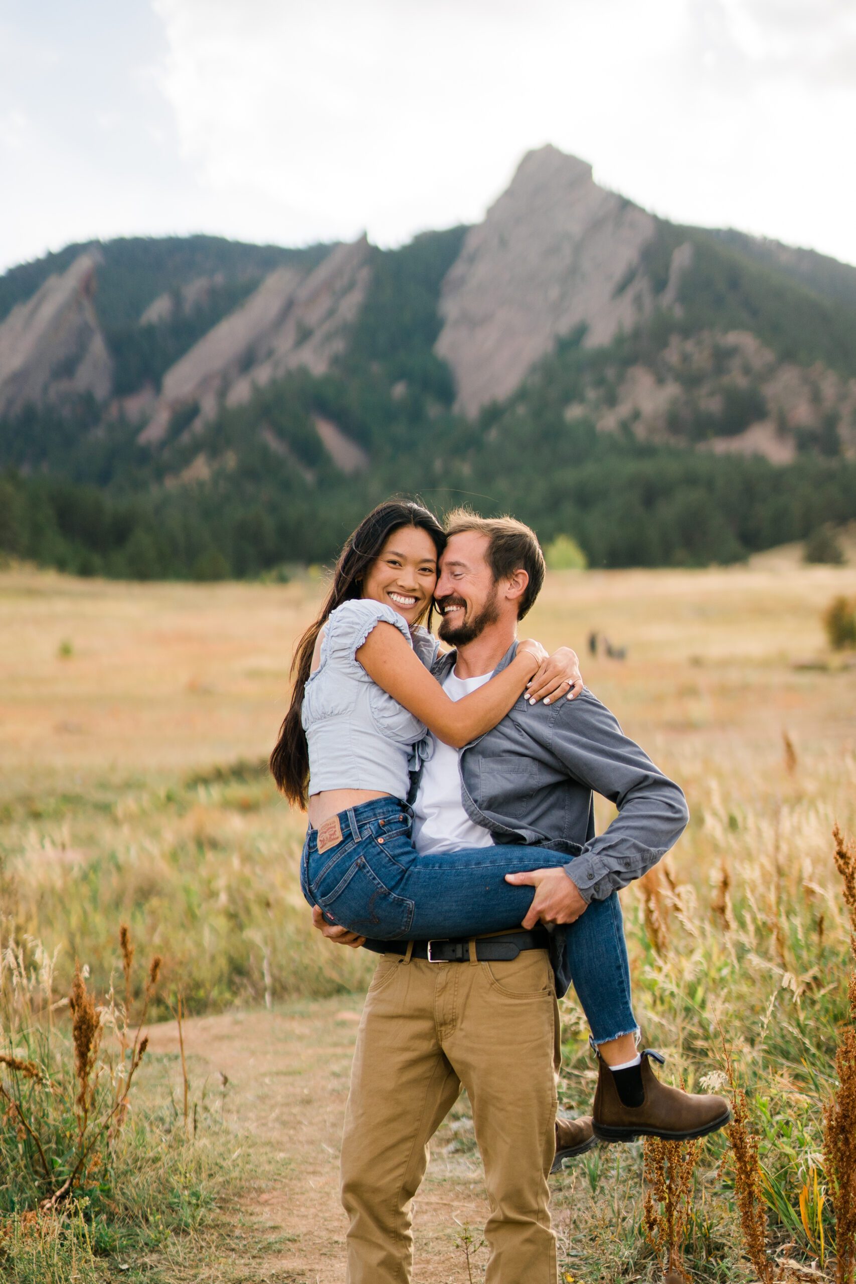 finacee holding on to her fiance during their Chautauqua park engagement photos in boulder Colorado