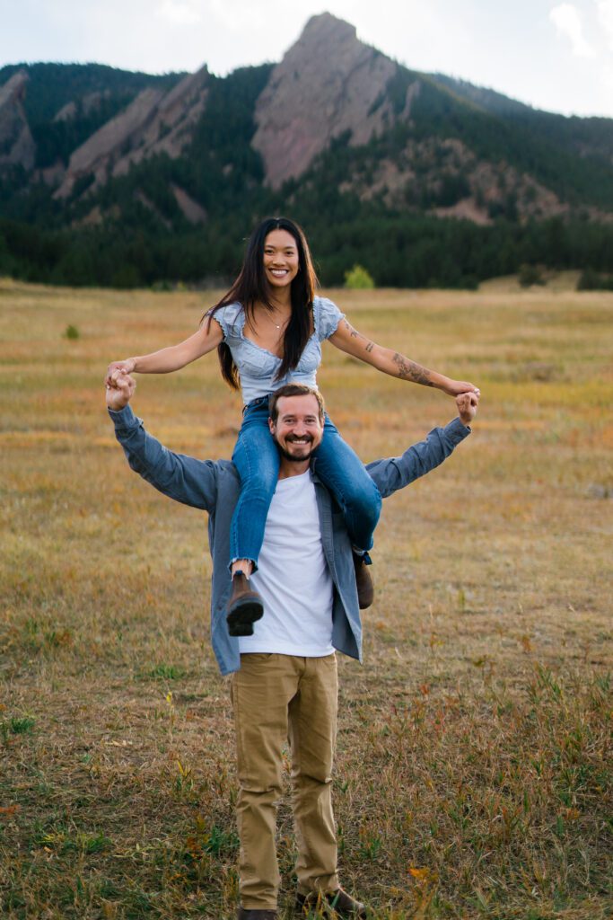 engaged couple with fiancée on top of her fiancé's shoulder during their Chautauqua Park Engagement Photos