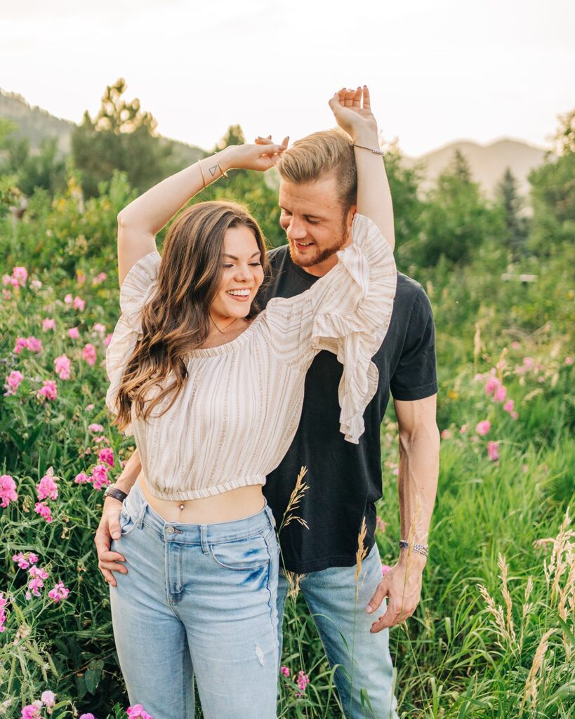 boyfriend and girlfriend standing in a field of flowers during their couples session in boulder colorado at chautauqua park 