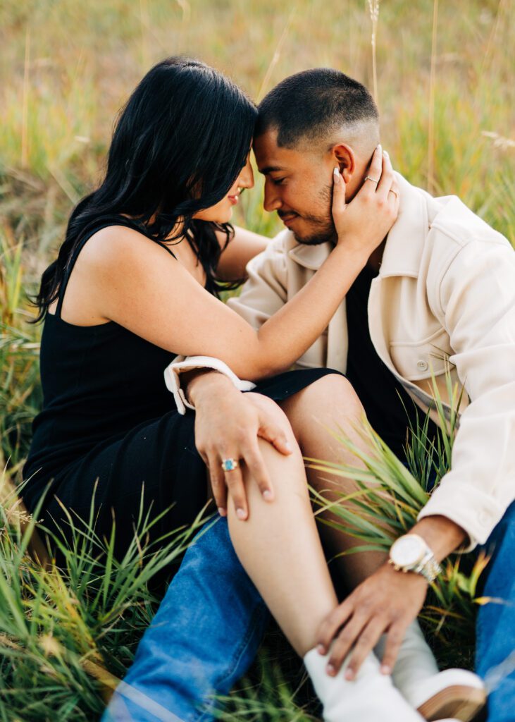 couple sitting in a field together at Chautauqua park in boulder colorado