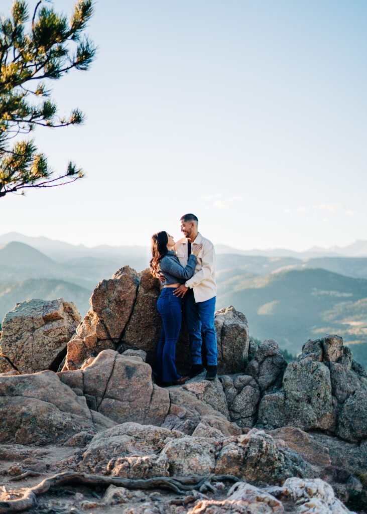 couple standing on a rocky mountain cliff edge at lost gulch overlook in boulder colorado during their couples photoshoot