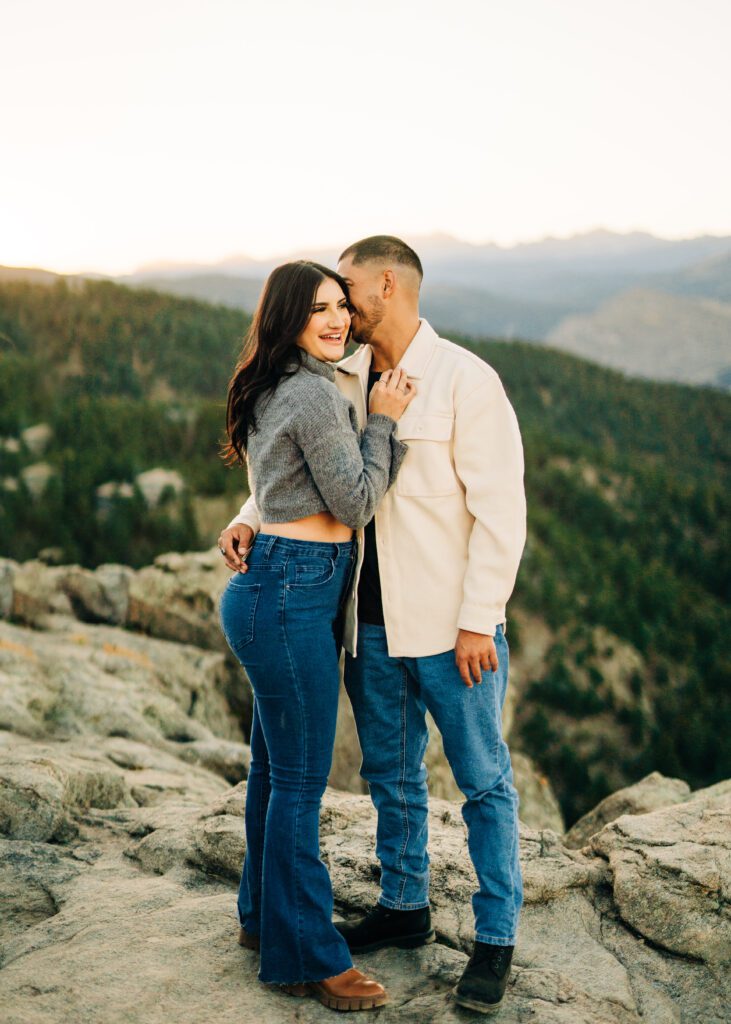 boyfriend whispering in his girlfriends ear during their couples session at lost gulch overlook in boulder colorado