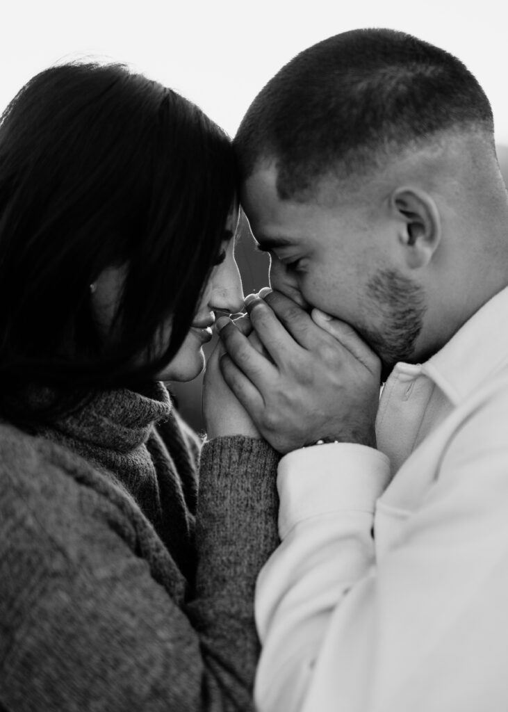 boyfriend and girlfriend holding hands up to their faces at lost gulch overlook in boulder colorado during their couples photoshoot