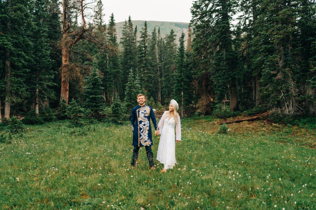 bride and groom holding hands in the forest at Brainard Lake Recreation area during their colorado elopement