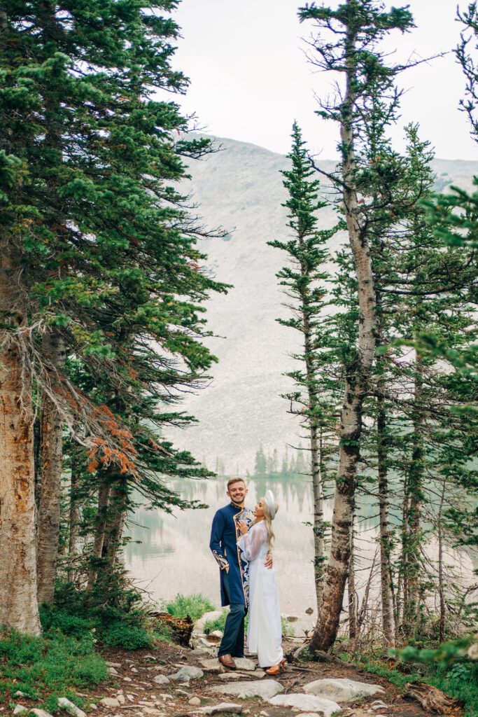 bride and groom snuggled up and smiling at each other during their colorado elopement hosted at Brainard Lake recreation area with lake mitchell in the backdrop