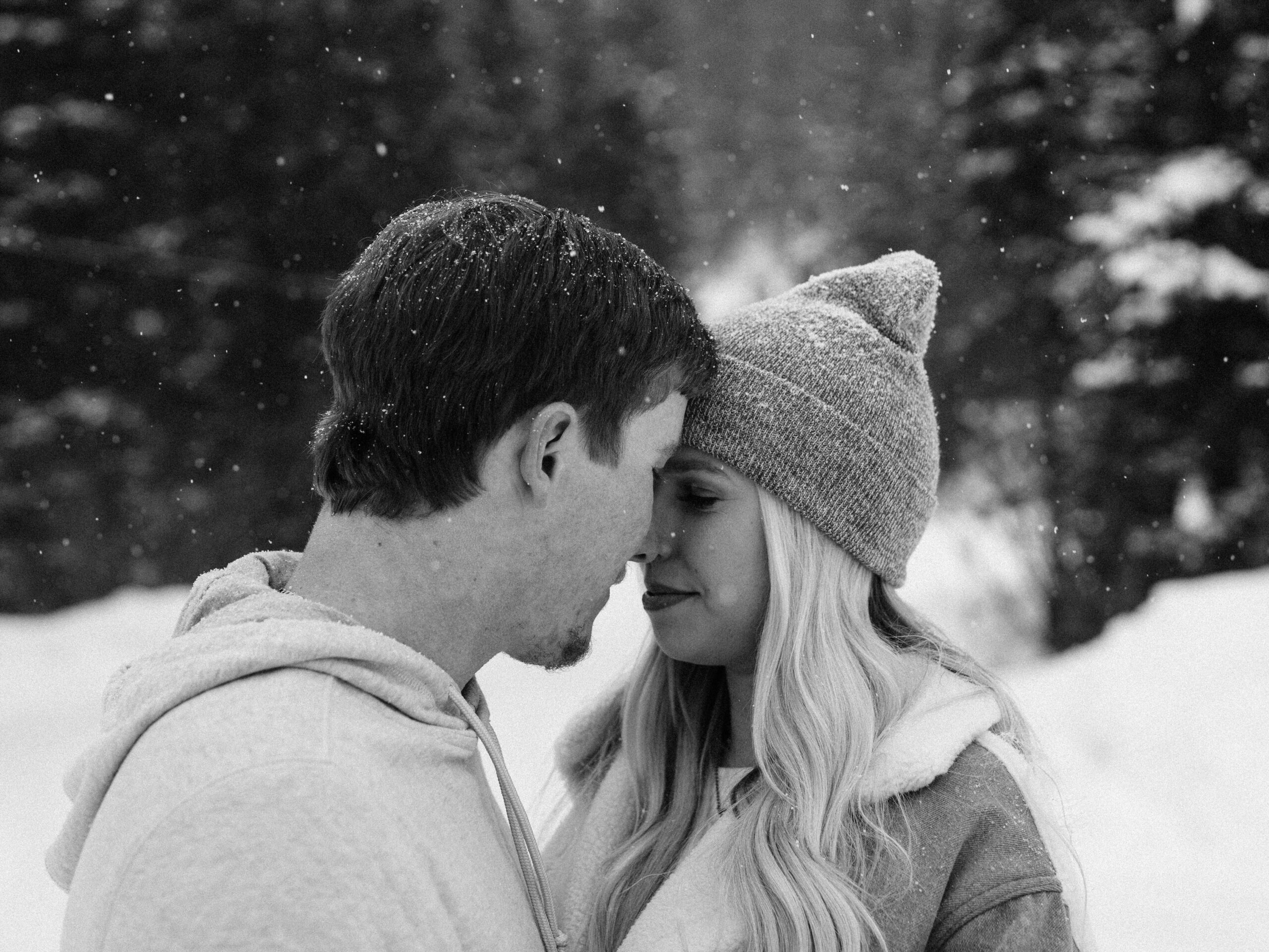black and white image of couple forehead to forehead during their snowy breckenridge engagement session