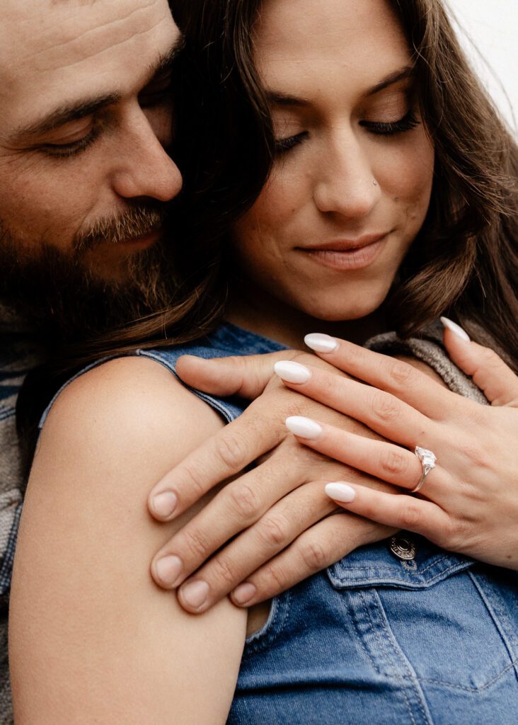 fiance nuzzling his girl friend with his arms wrapped around her during their colorado proposal photoshoot

