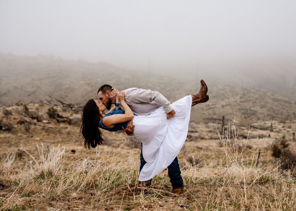 fiance dipping his girl friend while kissing her in a field during their proposal in colorado