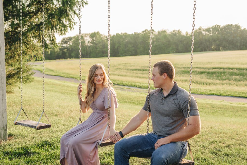 couple swinging on swings during their couples photoshoot