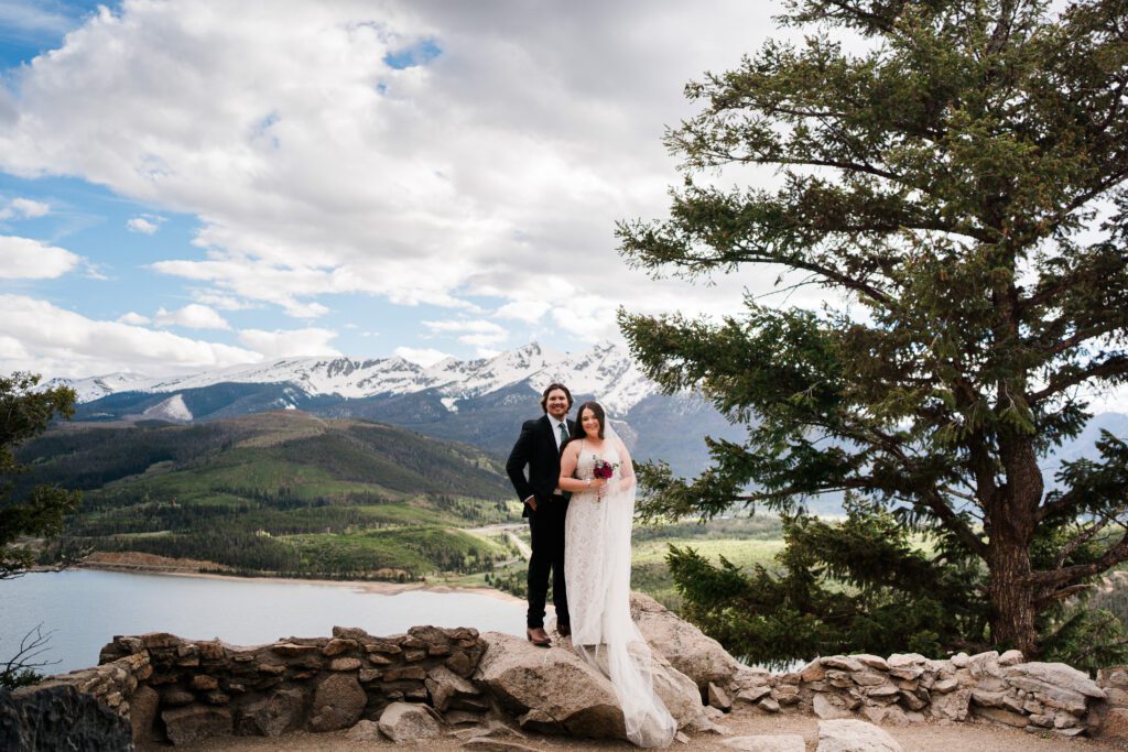 bride and groom holding hands and standing on cliff at Sapphire Point Overlook during their Colorado Elopement