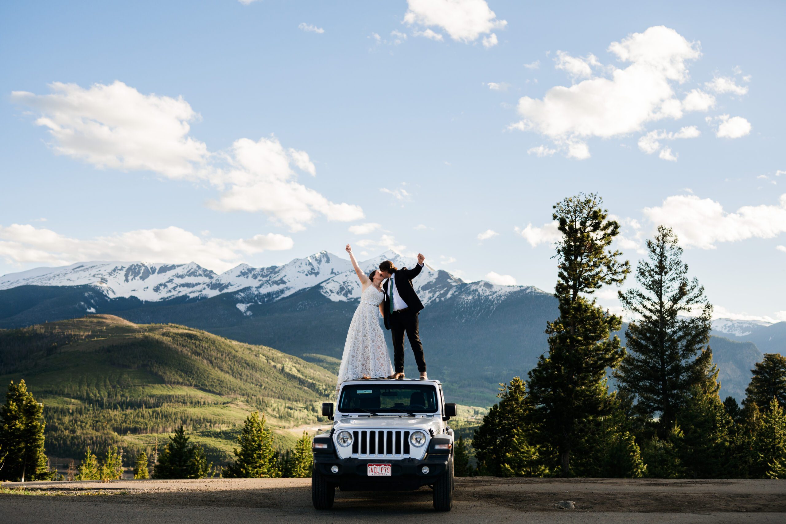 Bride and Groom Standing on top of a jeep kissing and holding hands at Sapphire Point Overlook in Colorado during their Colorado elopement