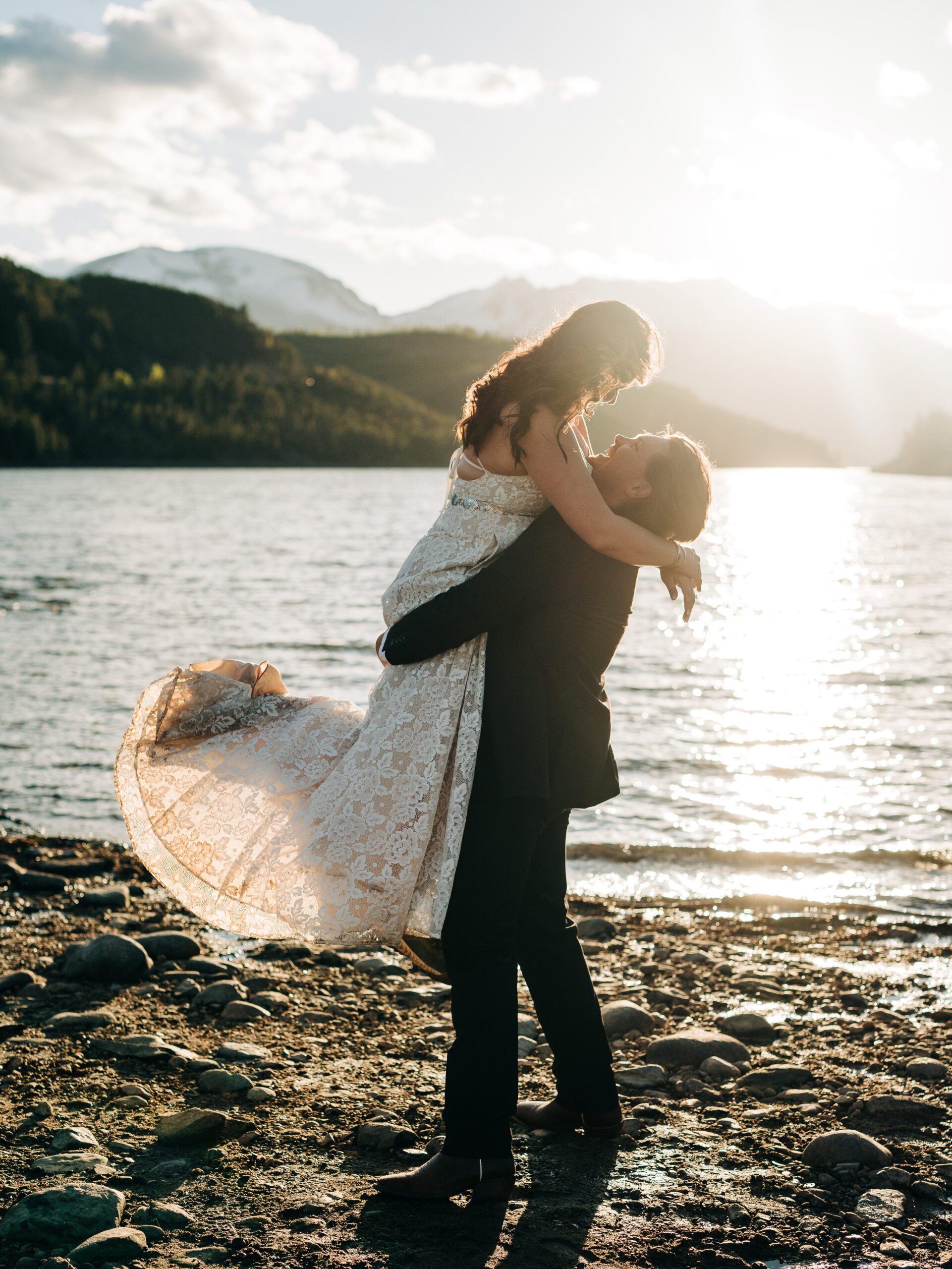 groom picking up bride on the beach of Dillon Lake Reservoir near Sapphire Point Overlook during their Colorado Elopement