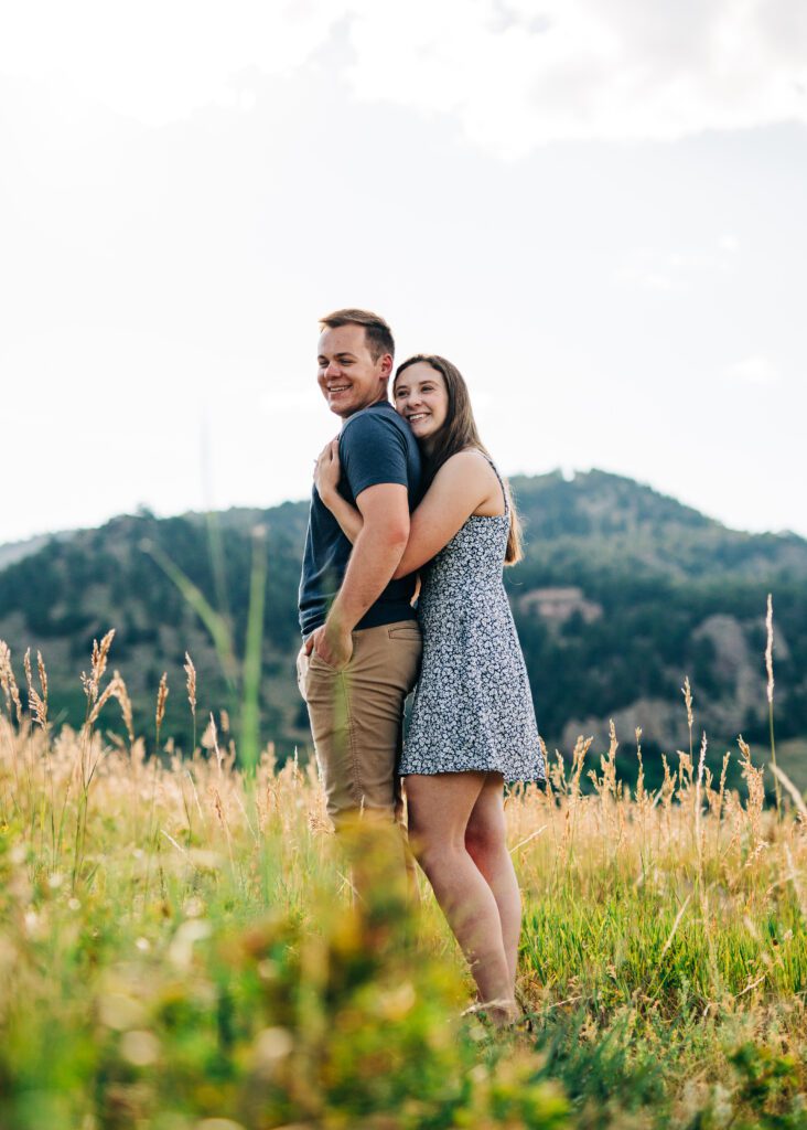 girlfriend hugging her boyfriend from behind during their boulder colorado engagement session