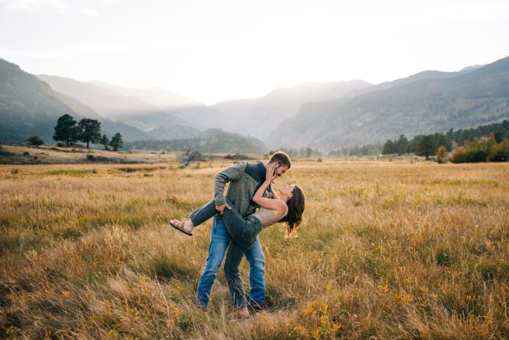 boyfriend dipping his girlfriend back and kissing her during their engagement session at Rocky Mountain National Park in Colorado