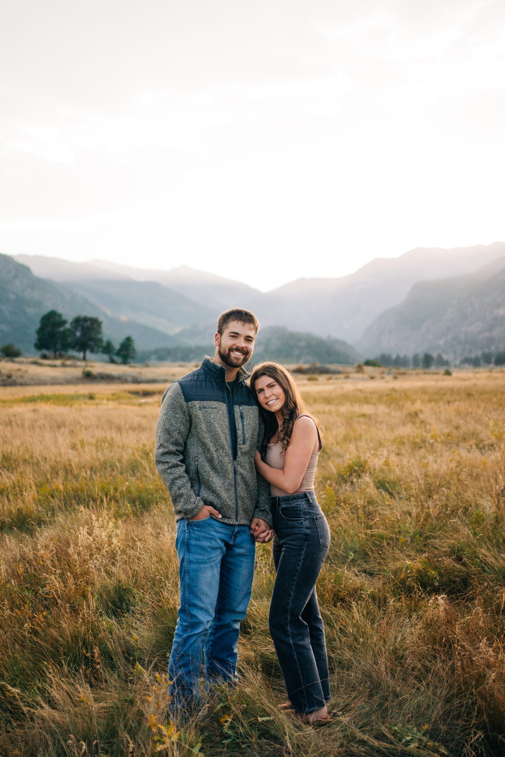 Kadi and Corwin smiling at the camera during their engagement session in Rocky Mountain National Park Colorado