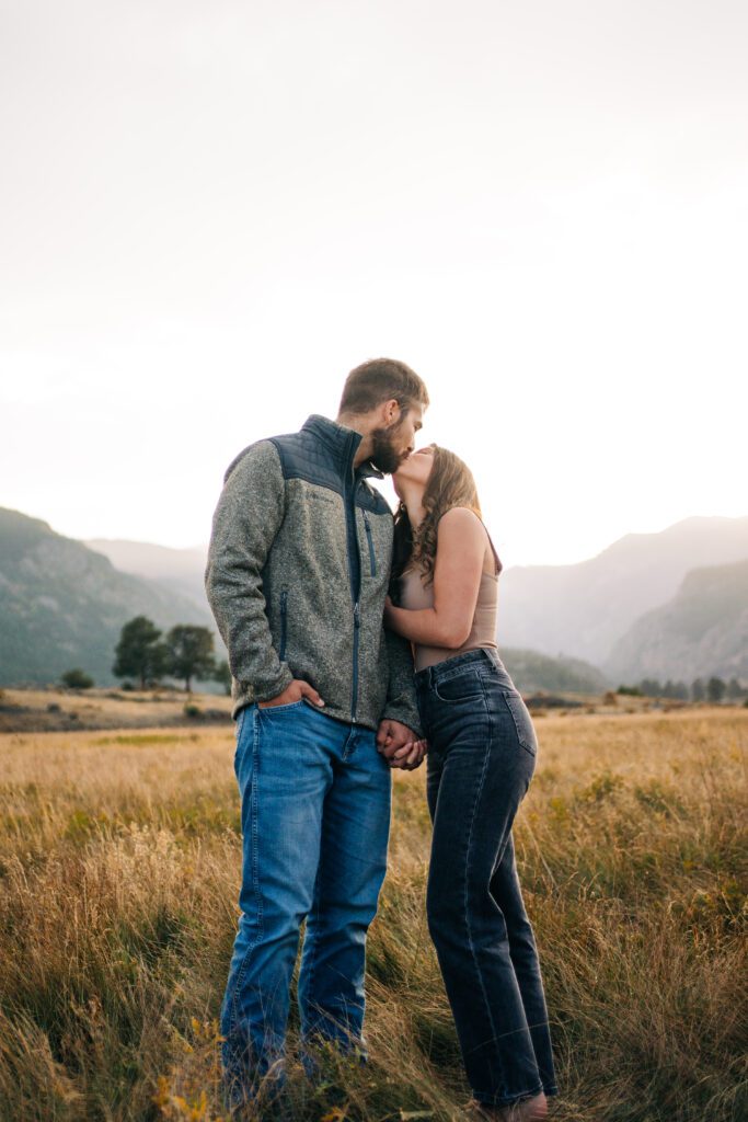 couple kissing in Moraine Park during their engagement session at sunset in Rocky Mountain National Park