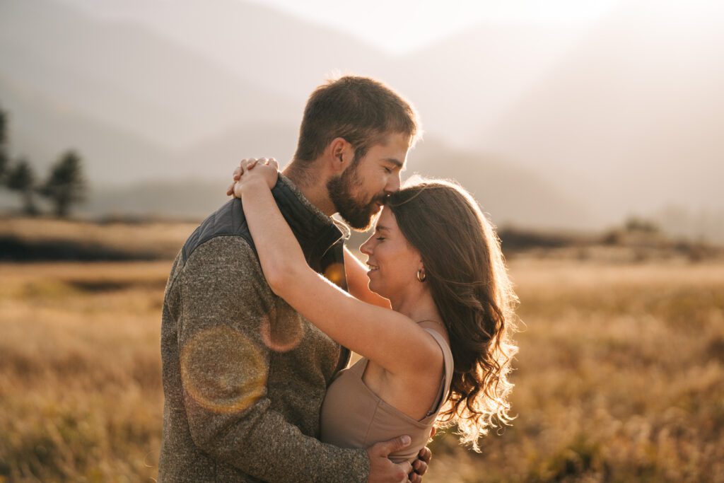 Corwin kissing kadi on the top of the head during their engagement session in rocky mountain national park 