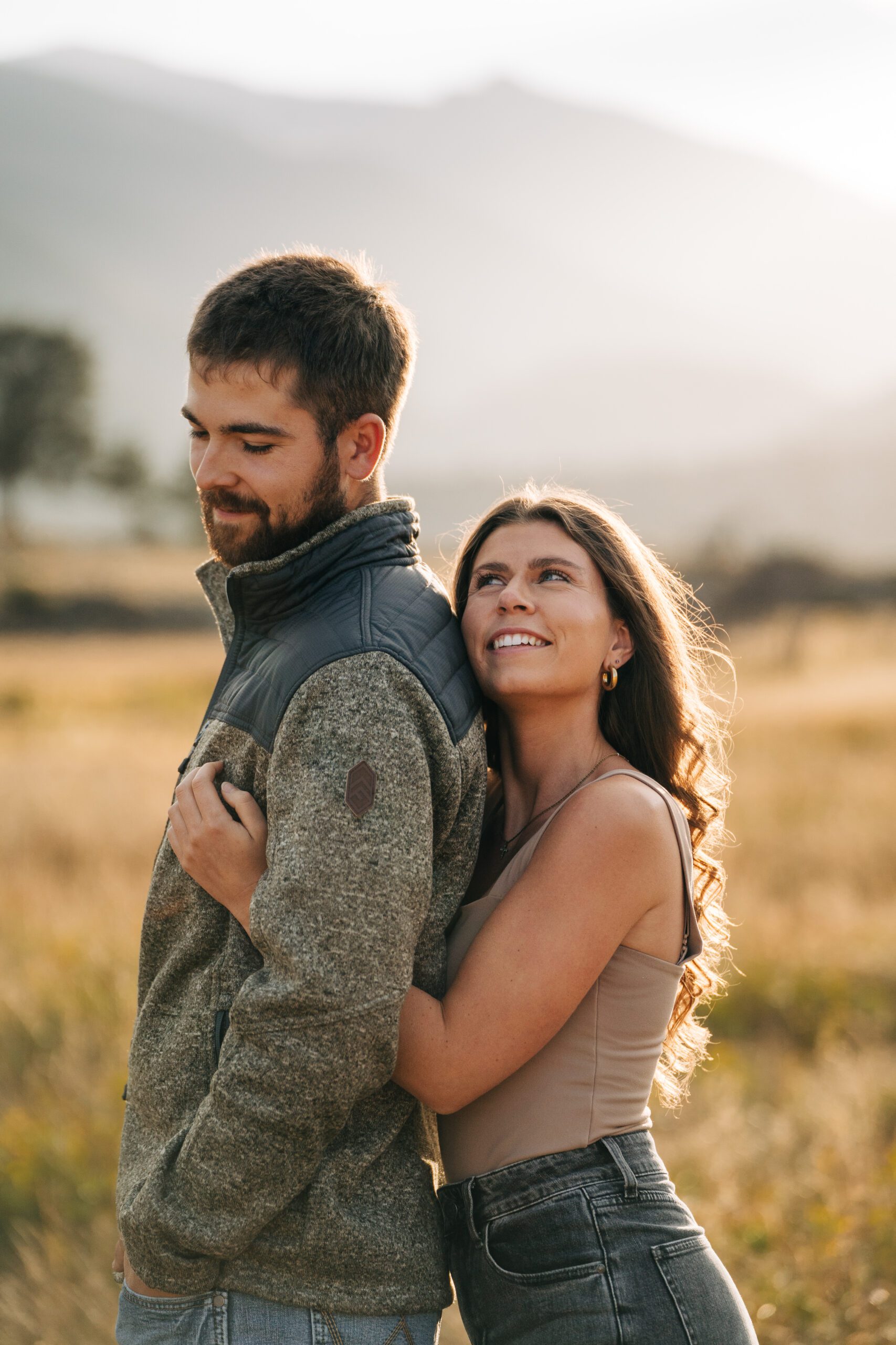 Kadi smiling up at Corwin during their engagement session in Rocky Mountain national Park