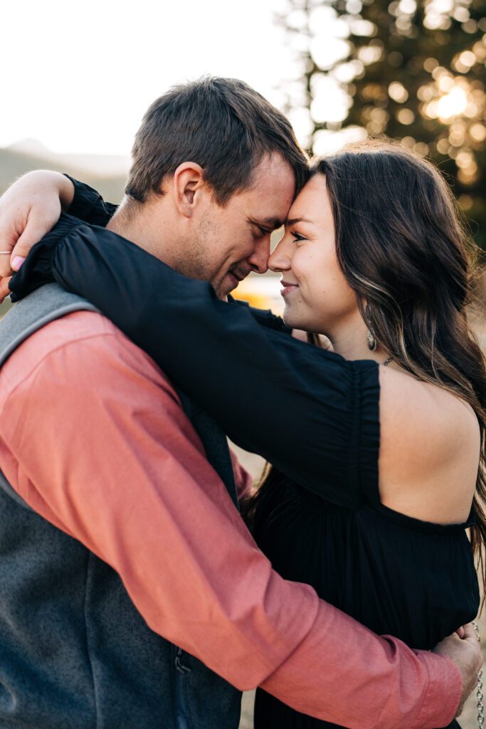 Cute engaged couple forehead to forehead smiling at each other during their Brainard Lake engagement session in Colorado