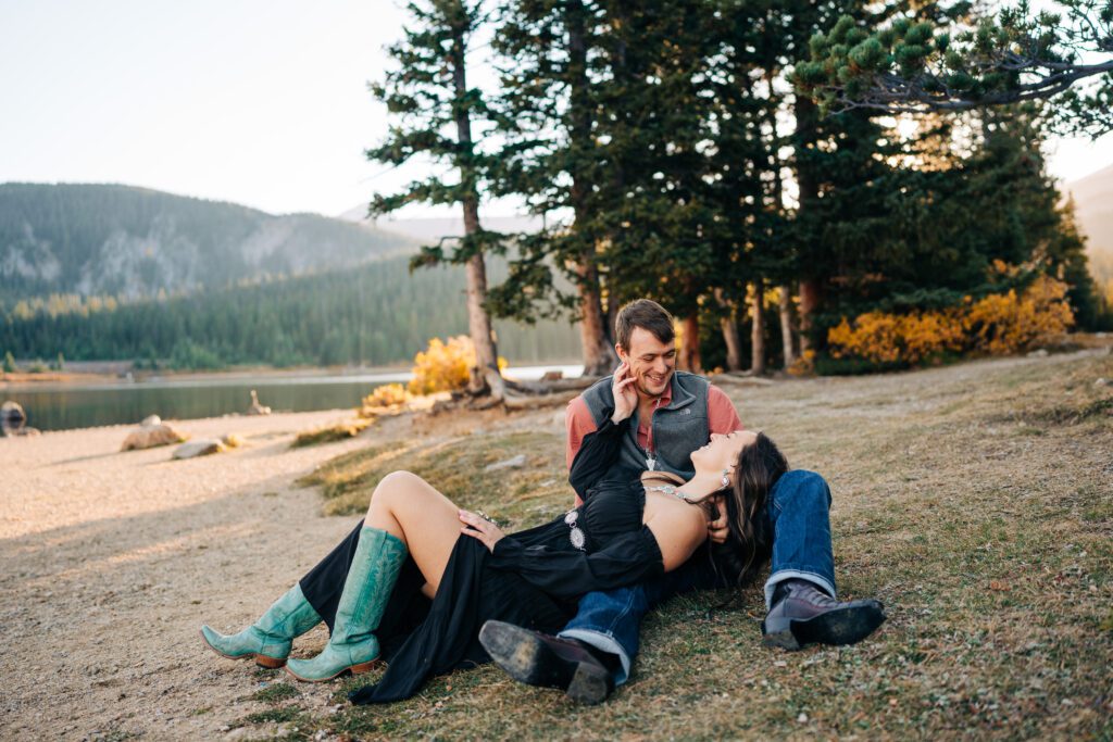 Girlfriend laying in boyfriends lap while she smiles up at him during their Brainard Lake Engagement Session in Colorado