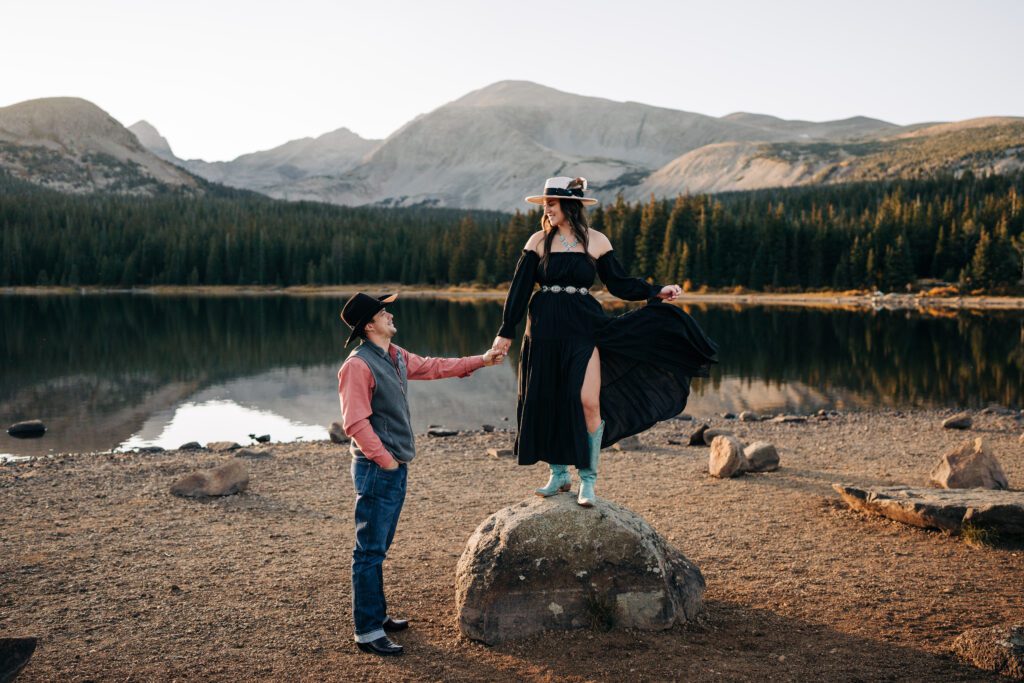 Engaged couple at Brainard Lake Recreation Area in Colorado holding hands and looking at eachother