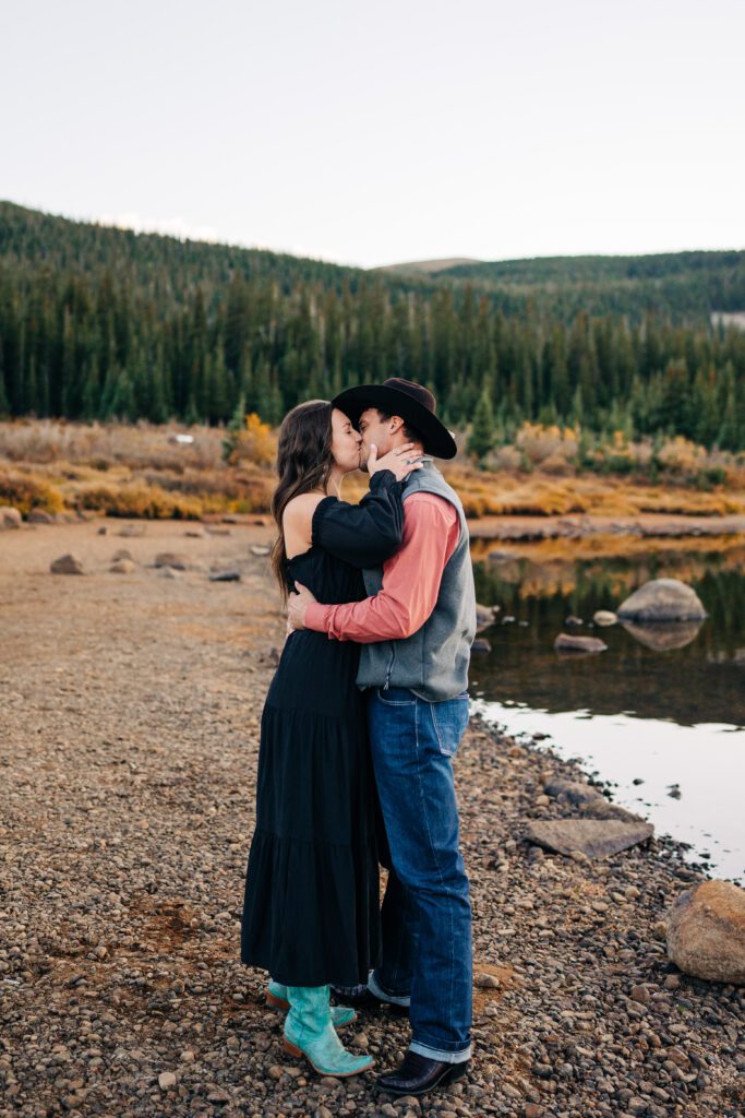 Engaged couple kissing after he proposed at Brainard Lake in Colorado