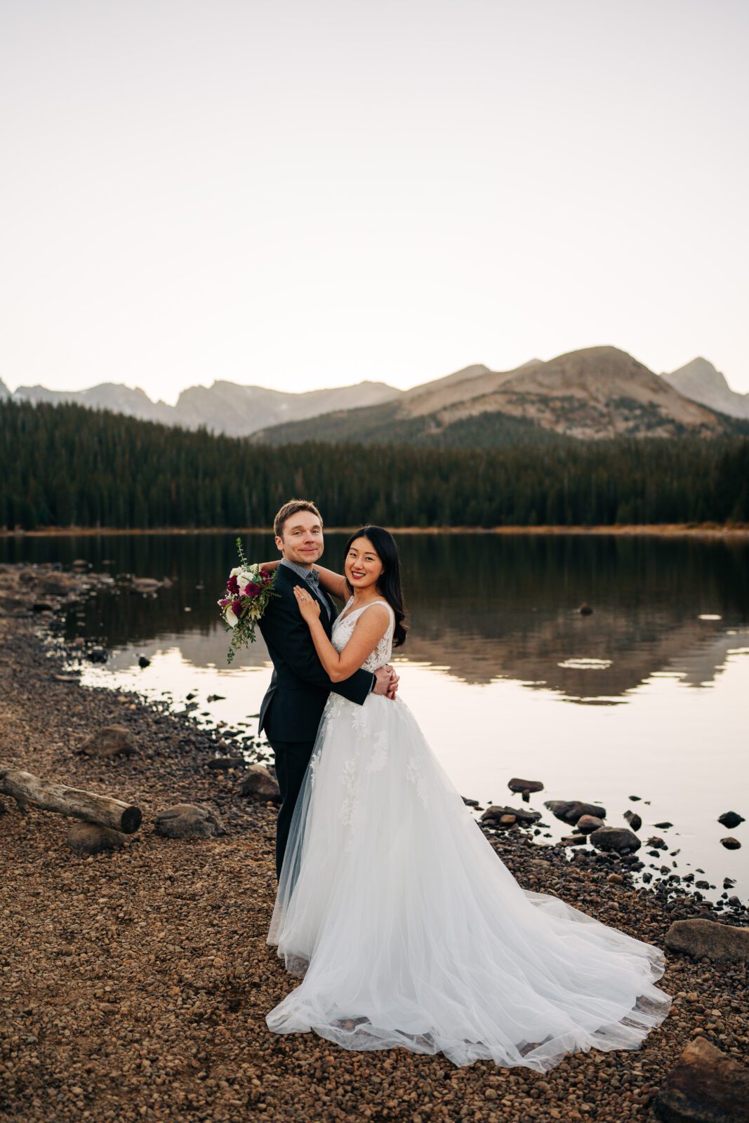 bride and groom hugging eachother while smiling at the camera during their brainard lake elopement