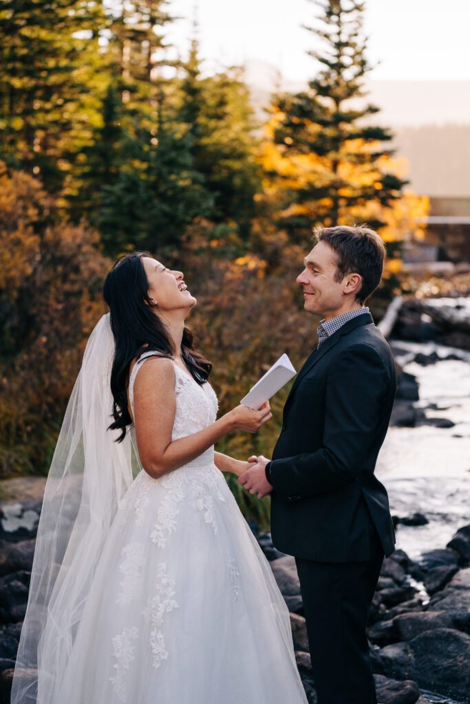 closeup of bride laughing while reading her wedding vows to her husband during their brainard lake elopement near boulder colorado