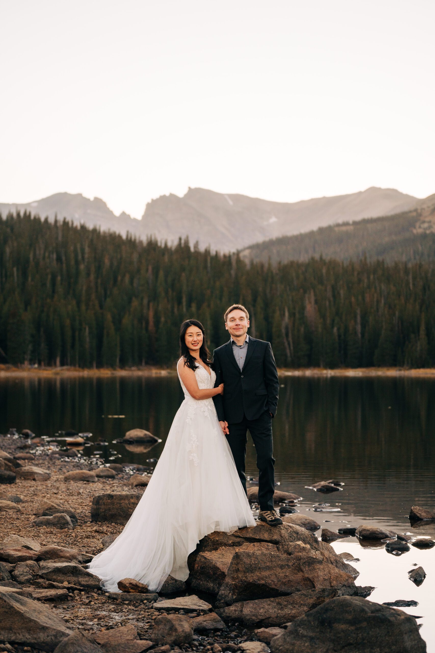 Bride holding onto grooms arm during sunset during their brainard lake elopement in colorado