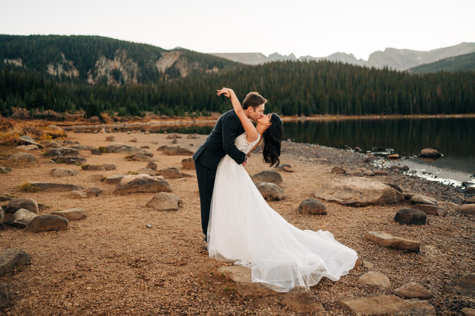 groom kissing the bride and dipping her backwards during their brainard lake elopement near boulder colorado