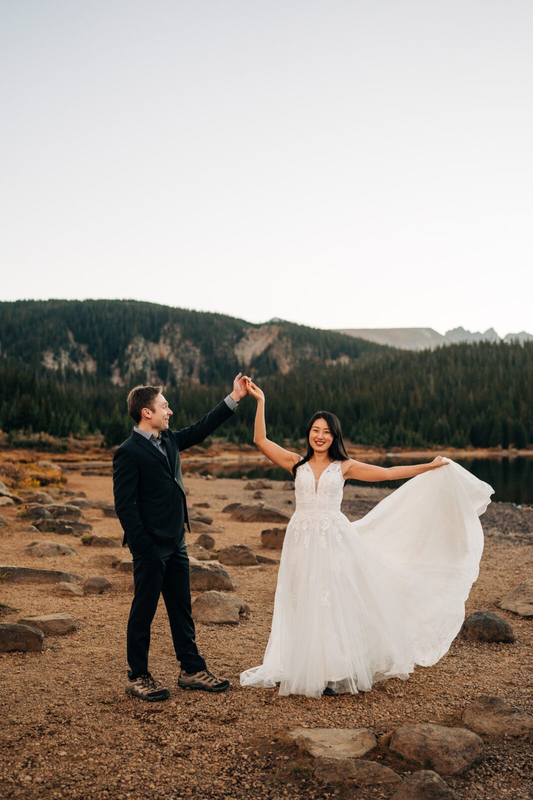 groom spinning bride during their first dance by the lake during their brainard lake elopement near boulder colorado