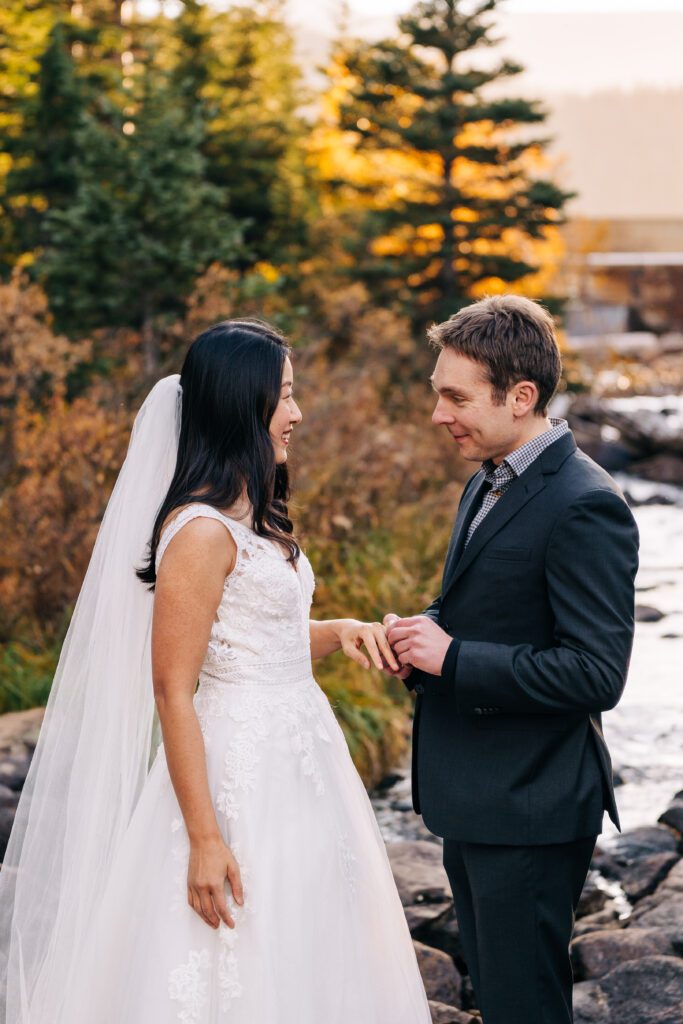 groom putting the ring on brides finger during their brainard lake elopement in boulder colorado