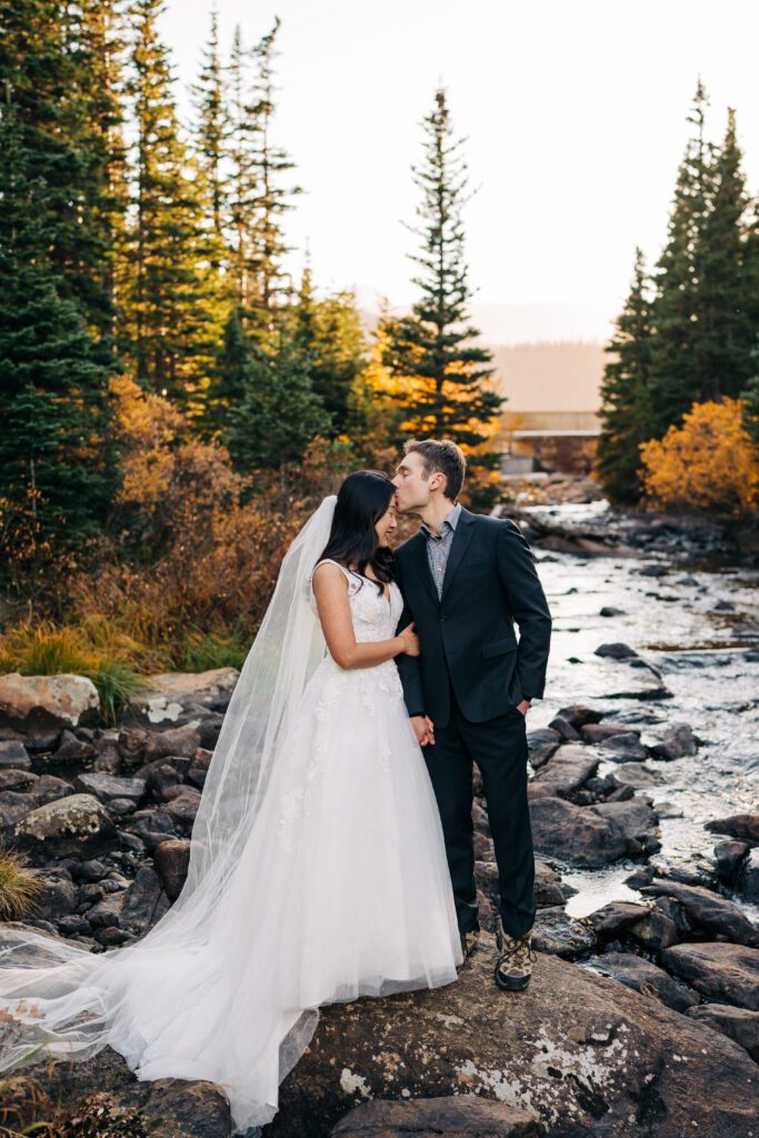 Groom kissing the bride on the forehead during their brainard lake elopement near boulder colorado