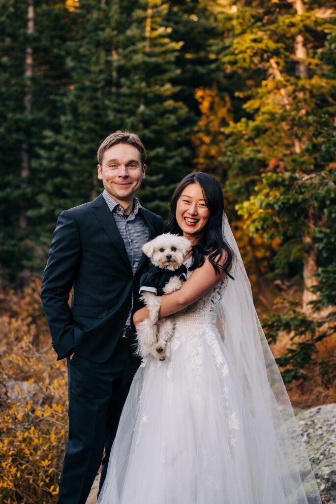 bride and groom holding their dog during their brainard lake elopement near boulder colorado