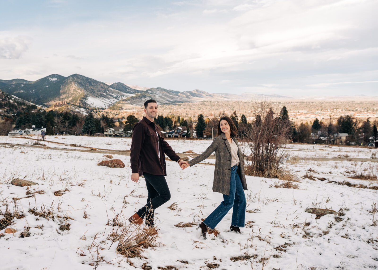 Modern engaged couple walking through the snowy field at Chautauqua Park in Boulder, Colorado during their winter engagement photos