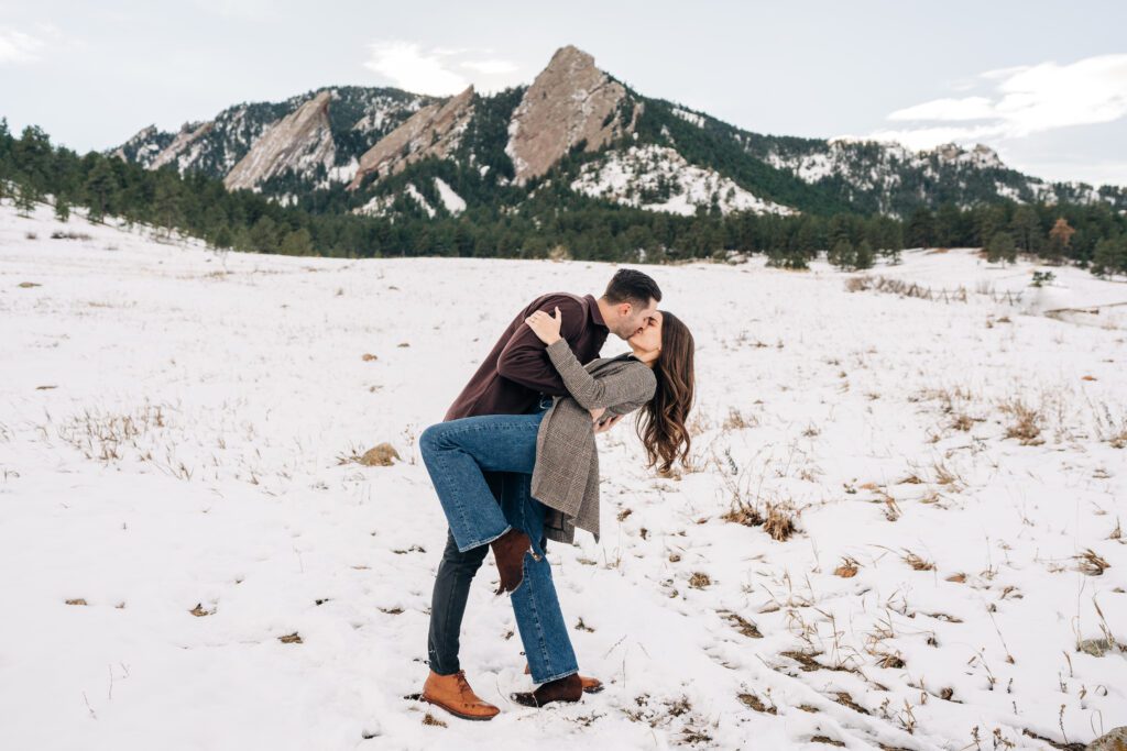 Engaged couple kissing and dipping after he just proposed to his girlfriend at Boulder, Colorado during their winter engagement photos