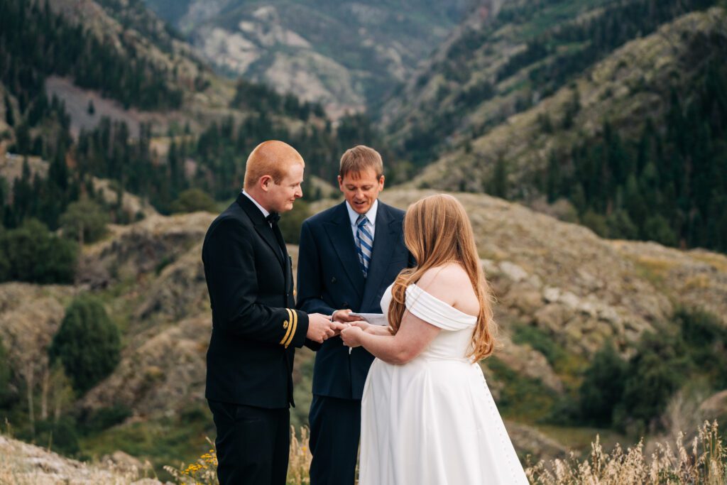 bride putting on grooms ring during their ouray elopement in colorado