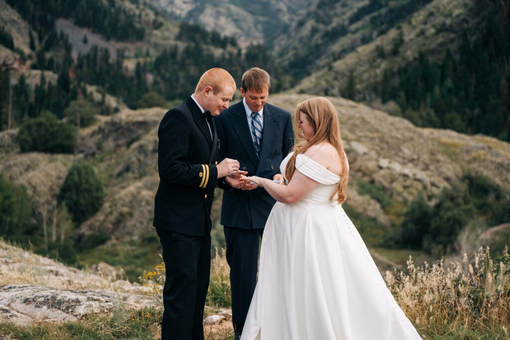 groom putting brides ring on during their ouray elopement ceremony in colorado