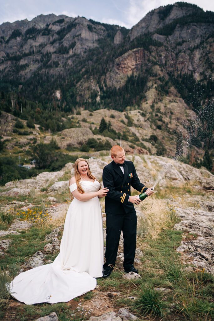 Bride and groom popping champagne during their ouray elopement in the mountains of colorado