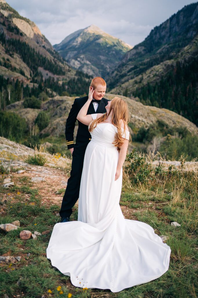 bride and groom cuddled up in front of a mountain during their ouray elopement in colorado