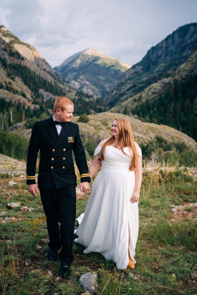 bride and groom holding hands walking towards the camera during their ouray elopement in colorado