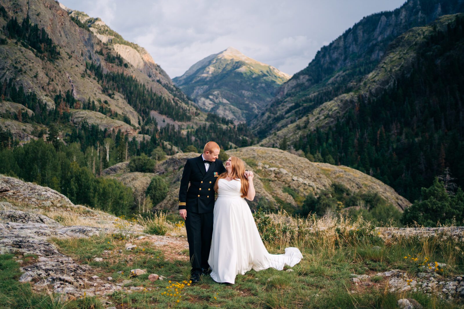 bride and groom holding hands and walking around in the mountains of colorado during their ouray elopement