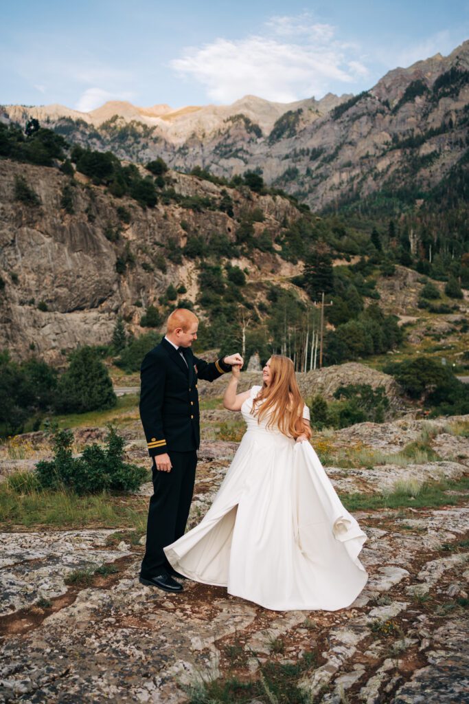 Groom spinning bride around on top of a mountain during their ouray elopement in the mountains of colorado