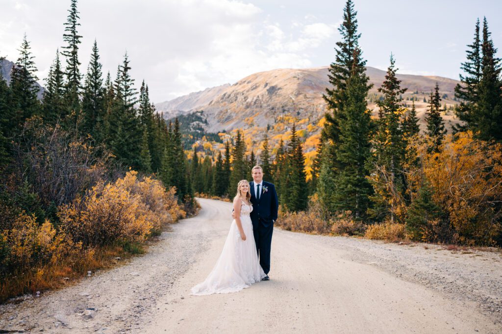 Bride and groom standing in the middle of the road during their autumn bridal portraits during their Breckenridge elopement