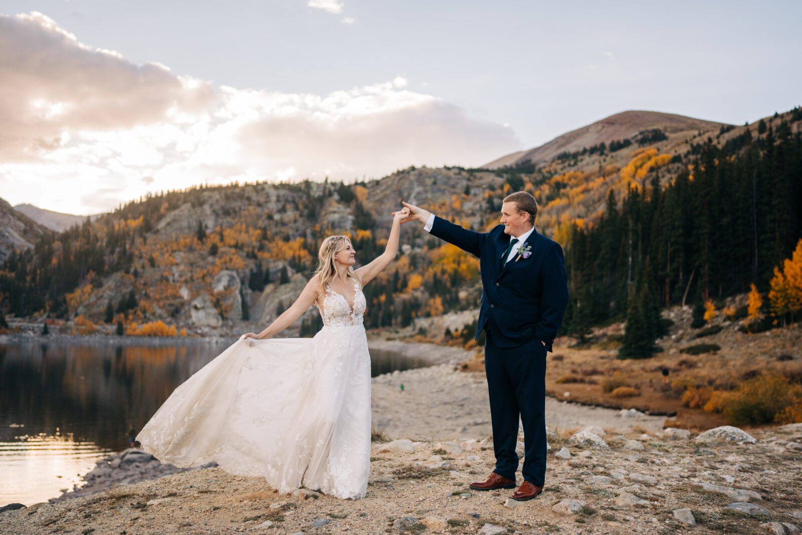 Groom twirling bride on the lakeshore of an alpine lake in Colorado during their Breckenridge elopement