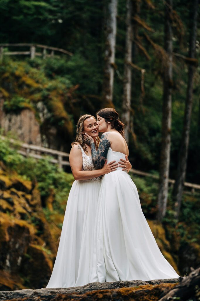 bride kissing her wives cheek during their washington elopement in mt rainier national park